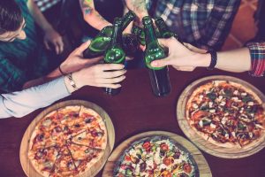 Friends enjoying pizza and beer